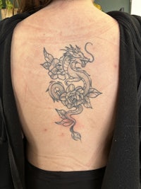 a woman with a dragon tattoo on her back