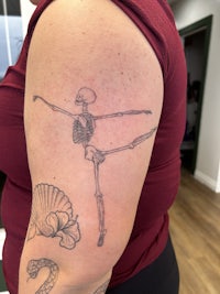 a woman with a skeleton tattoo on her arm