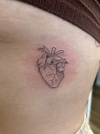 a tattoo of a heart on a woman's back