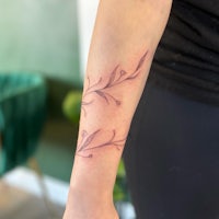 a woman's forearm with a flower tattoo