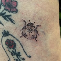 a ladybug tattoo on a woman's thigh