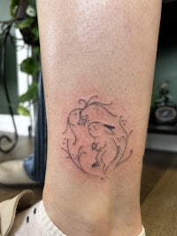 a woman's leg with a tattoo of a bird and a flower