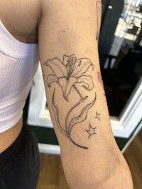 a woman with a tattoo of a flower on her arm