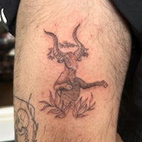 a tattoo of a goat on a man's thigh