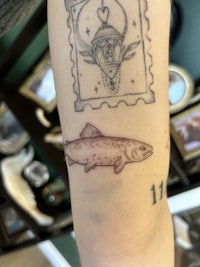 a tattoo of a fish on a person's arm